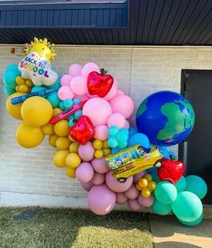 a bunch of balloons that are on the side of a building