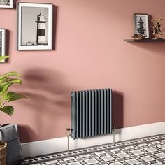 there is a radiator in the corner of this room with pictures on the wall