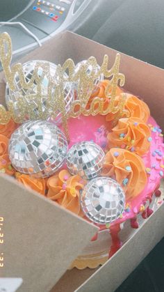 a box filled with disco balls and some decorations on top of the inside of it