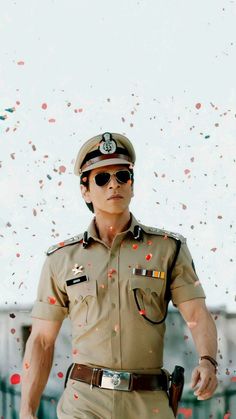 a man in uniform with sunglasses and confetti falling from the sky behind him