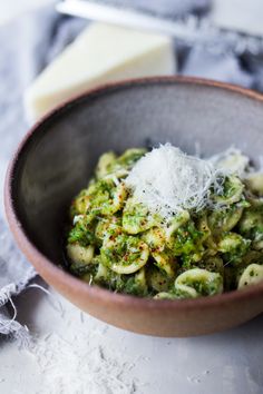 a bowl filled with pasta and cheese on top of a table