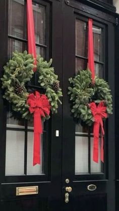 two christmas wreaths are hanging on the front door