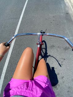 a woman riding a bike down a street