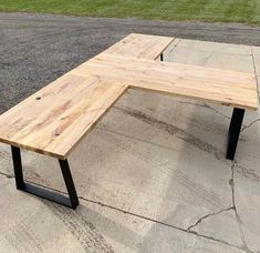 a wooden bench sitting on the side of a road