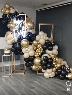 black and gold balloons are on display in an office space with white walls, wood flooring and gray floors