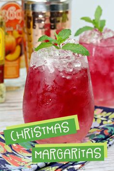 two glasses filled with christmas margaritas sitting on top of a table