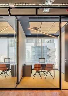 an office with glass walls and wooden chairs