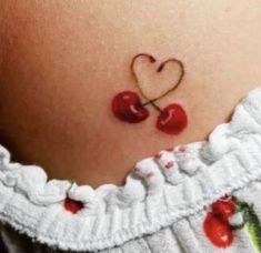 a woman's stomach with two cherries in the shape of a heart on it