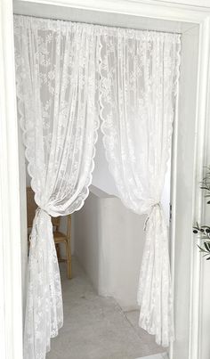 an open door with white curtains and lace on it