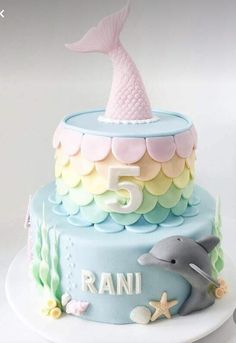 a birthday cake with a dolphin and fish decoration on the top, sitting on a plate