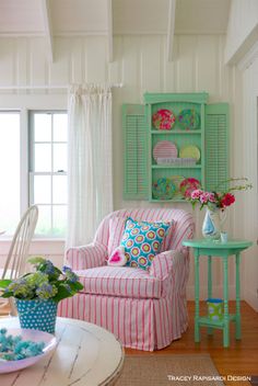 a living room filled with furniture and flowers in vases on top of a table