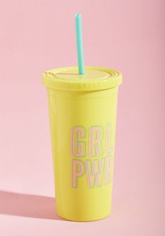 a yellow cup with a blue straw in it on a pink and white background that says girl power