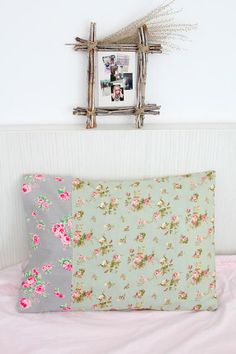 two pillows sitting on top of a bed next to a frame