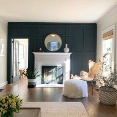 a living room with green walls and a fireplace in the center, surrounded by wicker furniture