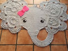 an elephant rug with a pink bow on it's head sitting on a tile floor