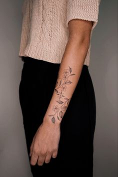 a woman's arm with a flower tattoo on the left side of her arm