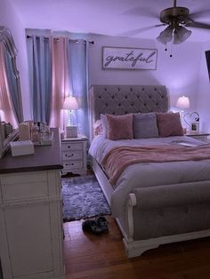 a bed room with a neatly made bed next to a dresser and a flat screen tv