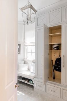 an open closet with white cabinets and drawers