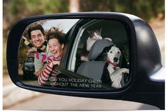 a rear view mirror with two people and a cat in the back seat on it