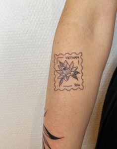 a woman's arm with a stamp on it and a flower tattooed on the wrist