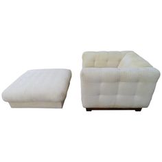 a white couch and footstool sitting next to each other