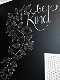 a chalkboard with the words be kind written on it in white letters and leaves