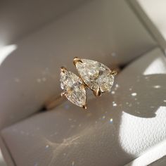 two pear shaped diamond engagement rings in a box