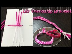 some pink and white string on top of a piece of paper