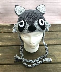 a crocheted hat with ears and eyes on top of a mannequin head