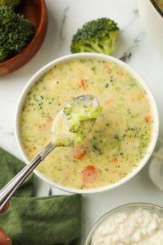 a bowl of broccoli cheese soup with a spoon in it