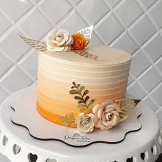 there is a cake that has flowers on the top of it and leaves on the bottom