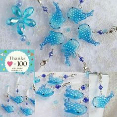 some blue birds are hanging from a chain on a white cloth with beads and pearls