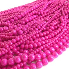 pink beads are lined up on a white surface