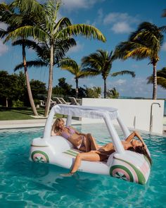 two women lounging in an inflatable pool on the side of a swimming pool