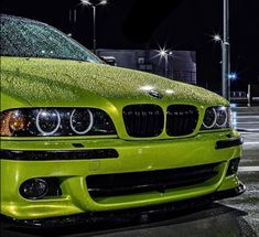 a green car parked on the street at night