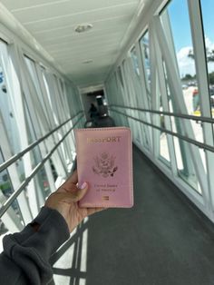 a person holding a pink passport in their hand