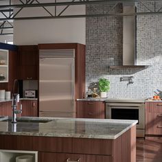 a modern kitchen with stainless steel appliances and wood cabinets