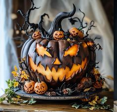 a cake decorated with carved pumpkins and leaves