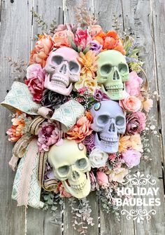 an arrangement of skulls and flowers on a wooden background with the words holiday baubles