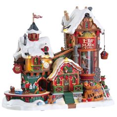 a christmas village is shown with snow on the roof and decorations in front of it