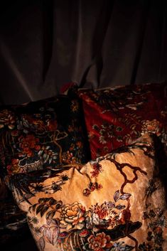 two decorative pillows on a bed in the dark