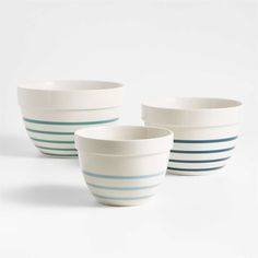 three white bowls with blue stripes on them