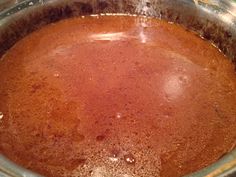 a pot filled with red liquid sitting on top of a stove