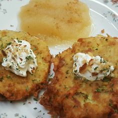 two crab cakes on a white plate with butter and parsley