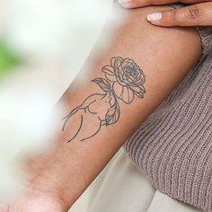 a woman's arm with a rose tattoo on the left side of her arm