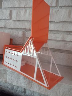 an orange and white shelf sitting on top of a stone wall