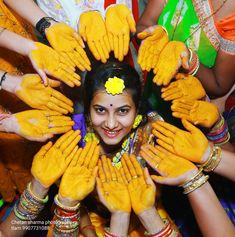 a group of people with yellow painted hands around the woman's face and arms