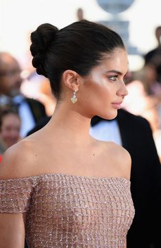 an image of a woman in a dress on the red carpet with people behind her