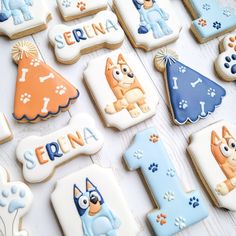 decorated cookies with the number one and dog's name are displayed on a table