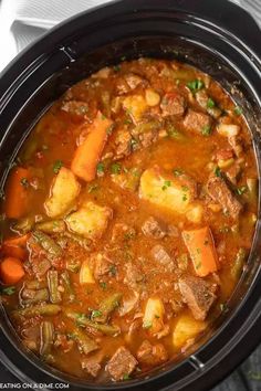 a crock pot filled with stew and vegetables